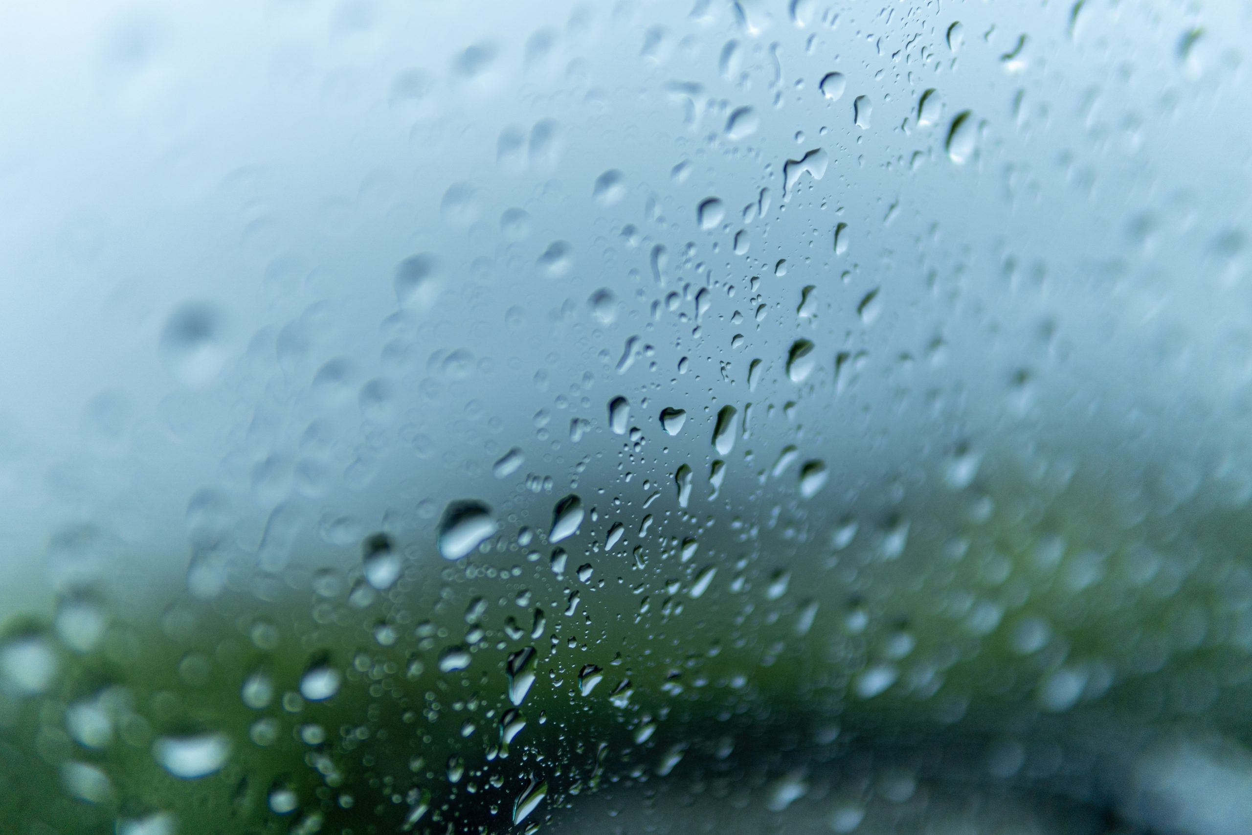 Closeup shot of the glass of a window covered by rain droplets - for backgrounds and textures